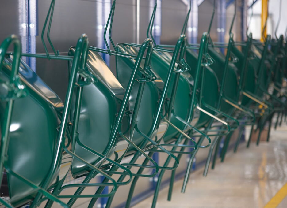 Green wheelbarrow frames on the powder coating line