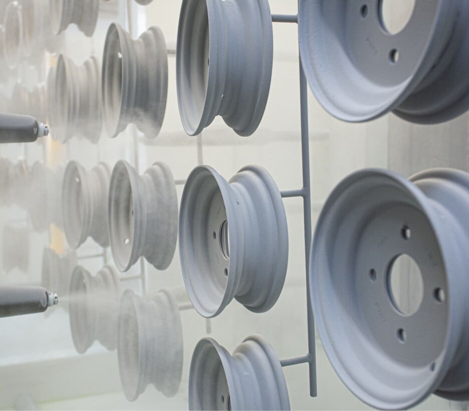 Steel rims on a hanging conveyor before powder coating